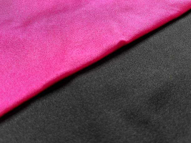 flache oberfläche aus schwarz und rosa glänzendem stoff - lycra stock-fotos und bilder