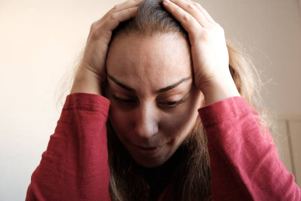 istock Woman suffering from headache at home 1458422465