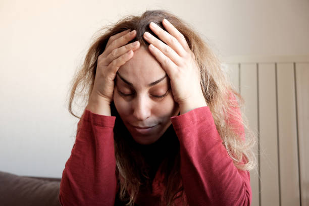 istock Woman suffering from headache at home 1458422471