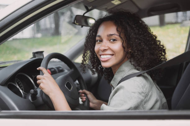 istock Smiling woman driving a car 1458422724