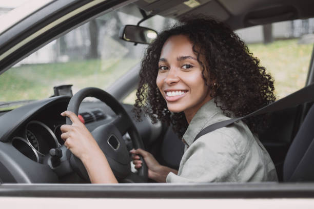 Smiling woman driving a car stock photo