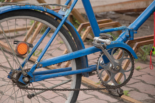 old blue bicycle stands in the yard close-up, bicycle
