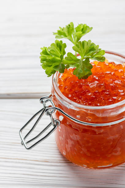 istock Red caviar in jar with fresh parsley 1458424248