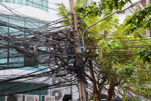 chaos von kabeln und drähten in bangkok, thailand, strom- und telefondrähte an einem laternenpfahl gewickelt - uncoordinated stock-fotos und bilder