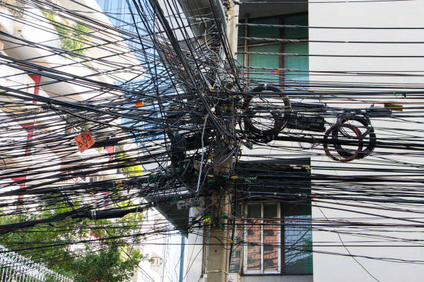 chaos von kabeln und drähten in bangkok, thailand, strom- und telefondrähte an einem laternenpfahl gewickelt - uncoordinated stock-fotos und bilder