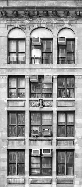 Black and white photo of an old townhouse facade, New York City, USA.