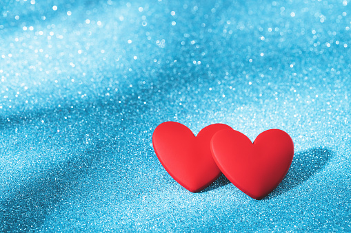 Two Red hearts, love greeting card. Bokeh blue abstract sparkling background. Valentines Day card or winter wedding