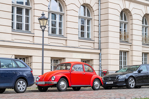Potsdam, Germany - January 02, 2023: Old red Volkswagen Beetle car on the street in the historic district in Potsdam, Germany. traditional german retro car