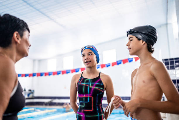 istock Teacher and kids talking in the poolside 1458435803
