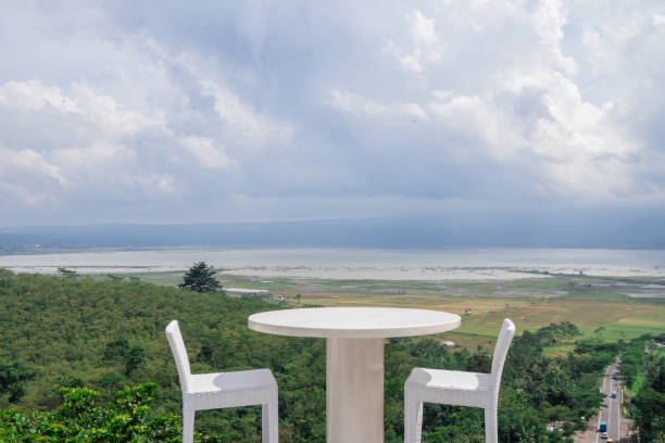 Empty white chair and table with beautiful background and cloudy sky.