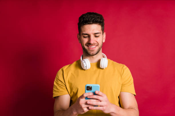 istock Cheerful young man with smartphone 1458441280