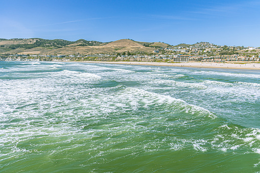 Pismo Beach is a picturesque coastal town with golden sandy beaches, clear blue waters and a lively atmosphere, perfect for activities such as swimming, sunbathing, and surfing.