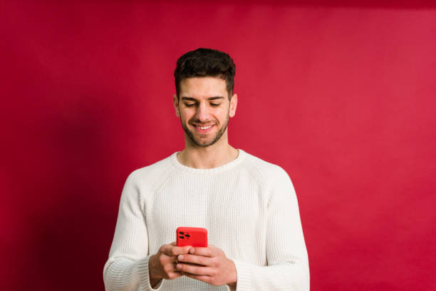 istock Cheerful young man with smartphone 1458447329