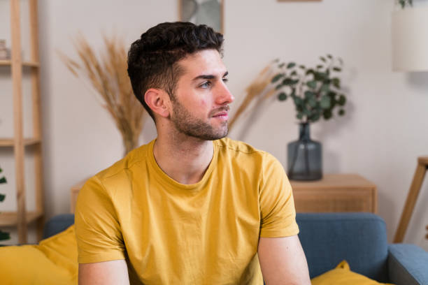 istock man sitting on sofa in living room 1458449448