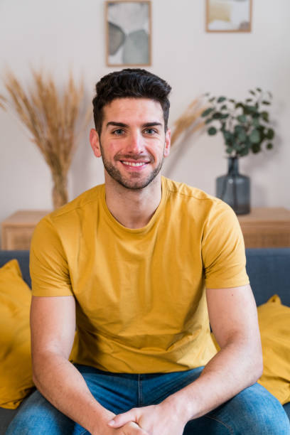 istock Happy man sitting on sofa in living room 1458449517