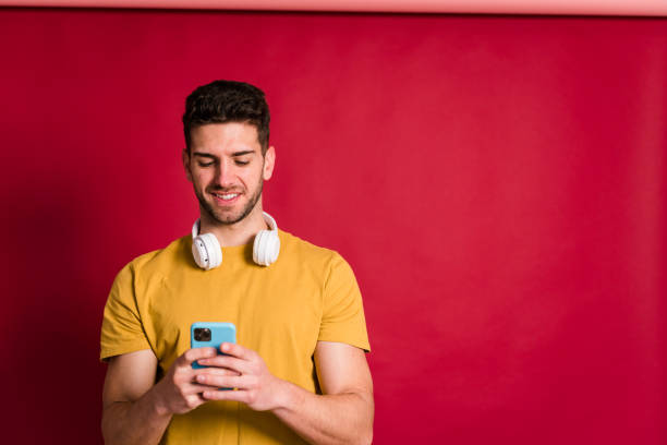 istock Cheerful young man with smartphone 1458449565