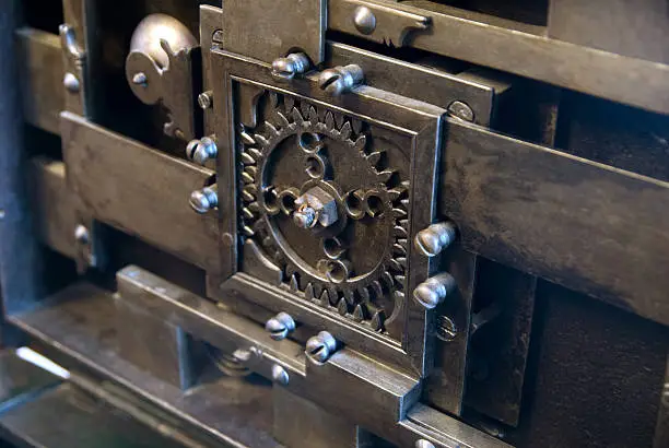 old steel mechanism with cog-wheel and bolt