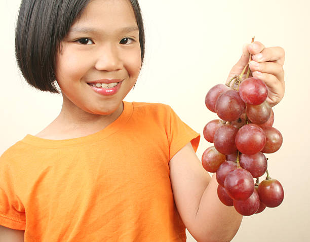 istock Young girl holding grapes. 145845102