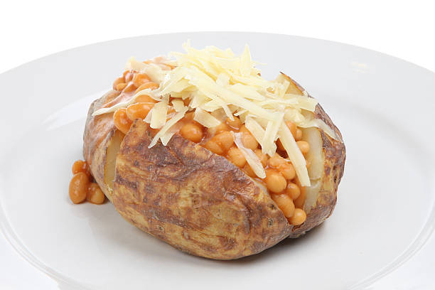 Jacket Potato with Baked Beans and Cheese Baked potato filled with baked beans and topped with Cheddar cheese baked potato stock pictures, royalty-free photos & images