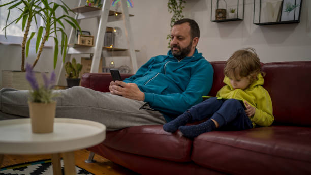 istock father with little son having fun with gadgets 1458460315