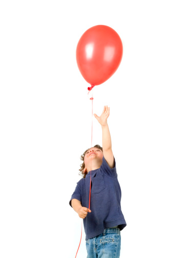 little boy holding red balloon