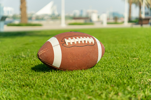 ball for American football on a grass field. Close up view with out of focus background.