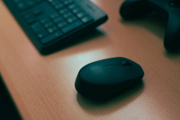 istock Mouse, keyboard, video game controller. Complements of a computer on a desk 1458463724