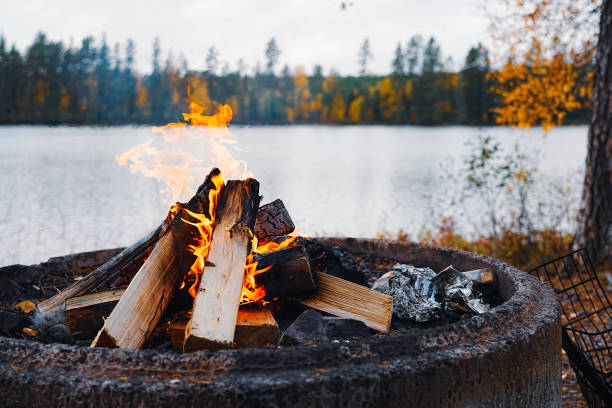 Beautiful bonfire and folding chairs near camping tent outdoors in evening