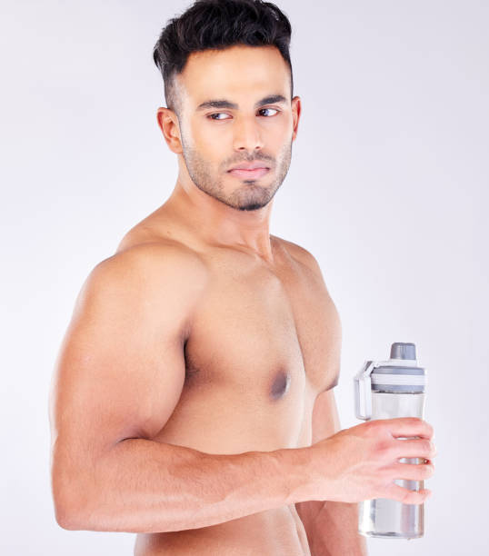 Fit Strong And Workout Break And Water Bottle With A Man Ready To Drink  Water On A Grey Studio Background Bodybuilder Drinking Water And Exercise  Or Training Break For Thirsty Hydration Stock