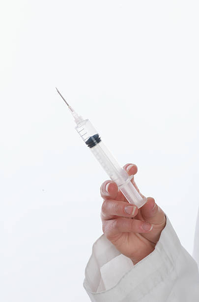 istock Female doctor's hand holding syringe close-up 145847001