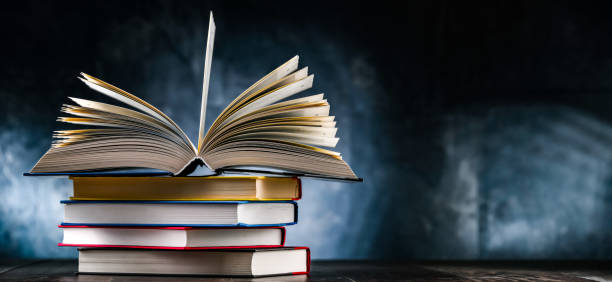 istock A composition with an open book lying on a stack of other books 1458473923