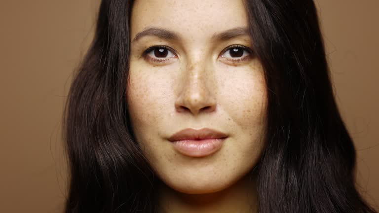 Close-up of Confident Mixed Race Woman against Brown Background