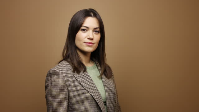 Portrait of Young Businesswoman Standing in Front of Brown Background