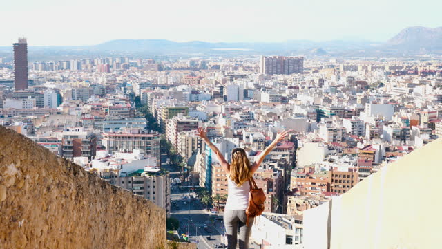 Happy woman tourist enjoying panoramic view of Alicante city in Spain
