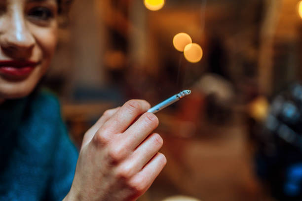 istock Young woman smoking a cigarette 1458480832