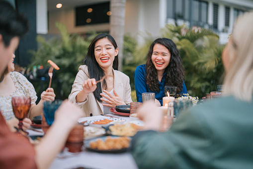 Asian Chinese Lesbian couple and Friends enjoying outdoor dining together