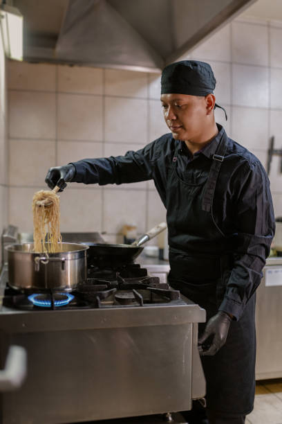 istock A chef in a black uniform prepares a meal. 1458481723