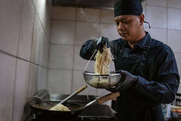 istock A chef in a black uniform prepares a meal. 1458481789