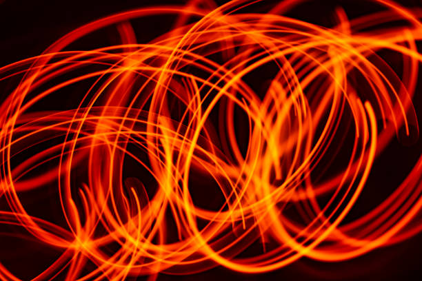 istock abstract glowing orange light trails on dark background 1458481850