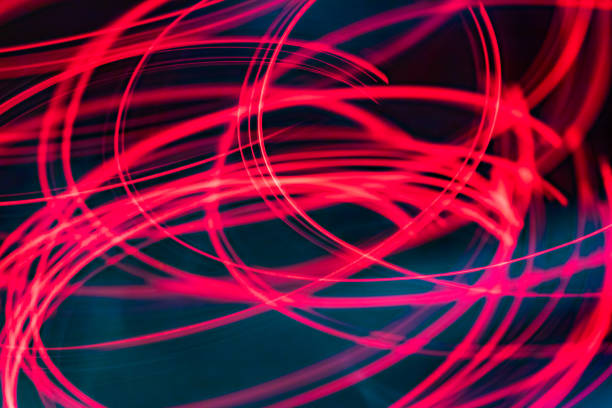 istock abstract glowing pink light trails on dark background 1458481851