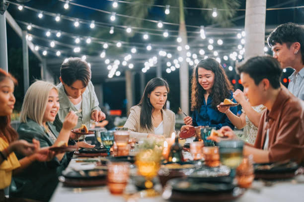 Asian Chinese Lesbian Couple celebrating birthday outdoor dining with friends stock photo