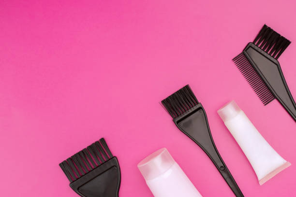 istock brushes and tubes for coloring hair on a pink background, copy space 1458482432