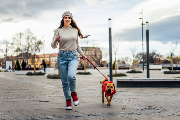 istock Young woman running with her dog 1458482733