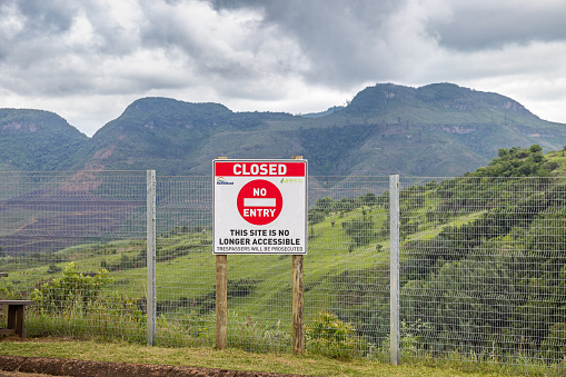 Drakensberg Mountain Range, South Africa - December 6th 2022: No entry sign and fence in front of a beautiful landscape in the Drakensberg Mountains