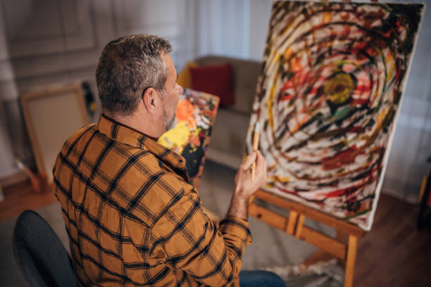 istock A male artist paints on a canvas in his studio 1458483875
