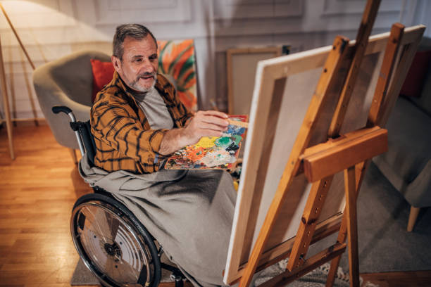 istock A man in a wheelchair paints on a canvas in a studio 1458485426