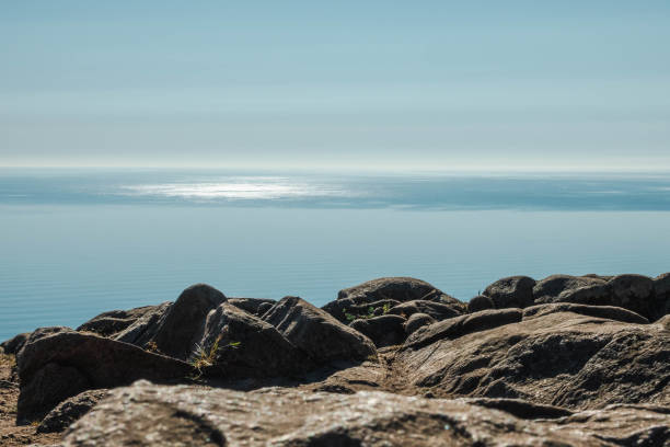 istock Mysterious seascape. Sun reflected on the water. Rocks in the foreground 1458487412