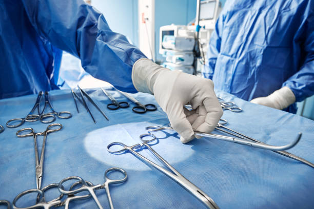 primo piano di strumenti chirurgici sterilizzati e pronti all'uso sul vassoio medico durante l'intervento chirurgico in sala operatoria dell'ospedale - apparecchiatura chirurgica foto e immagini stock