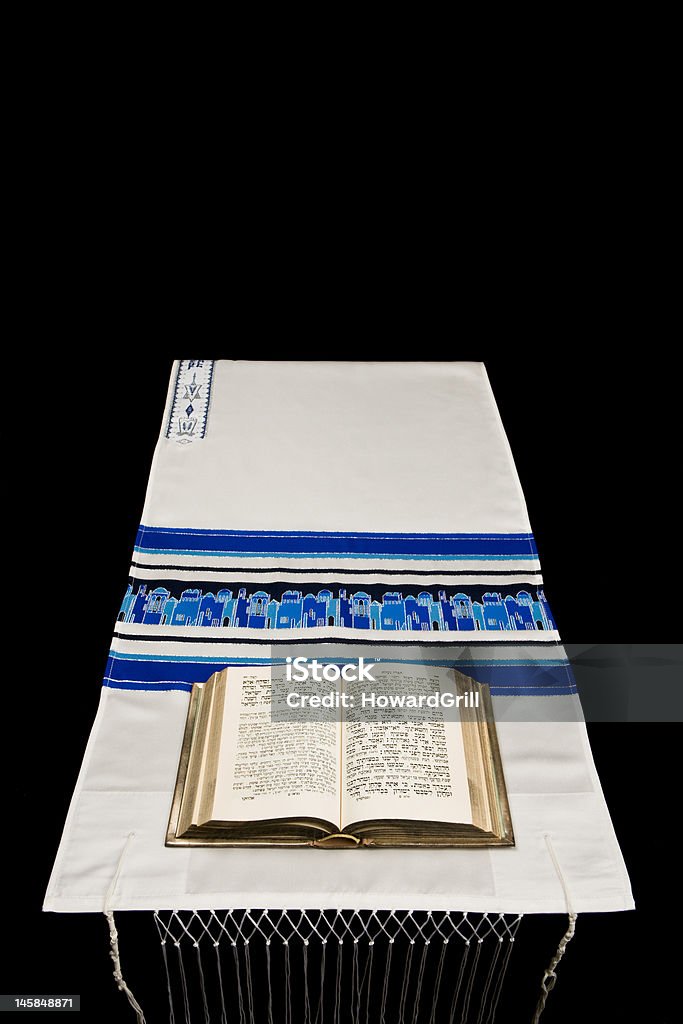 Jewish Prayer Shawl, Or Tallit, And Book Of Prayers, Siddur A Jewish prayer book, or Siddur, on a prayer shawl, or tallit, against a black background with room for text. Bar Mitzvah Stock Photo