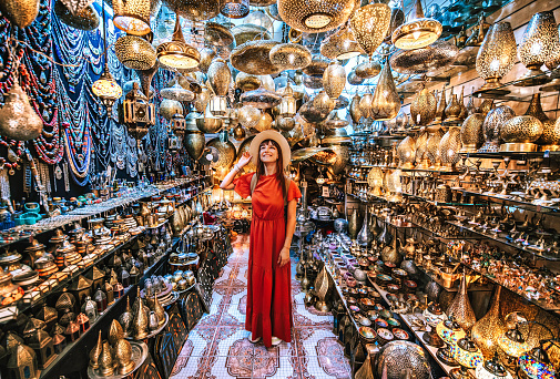 Young traveling woman visiting a copper souvenir handicraft shop in Marrakesh, Morocco - Travel lifestyle concept